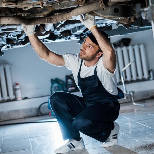 Mitarbeiter mechaniker bei der Reparatur eines Autos